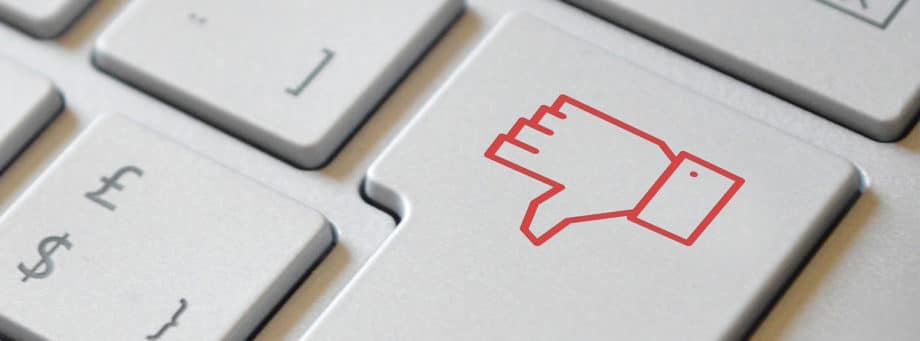 A close up of a red thumbs down sign on a keyboard.
