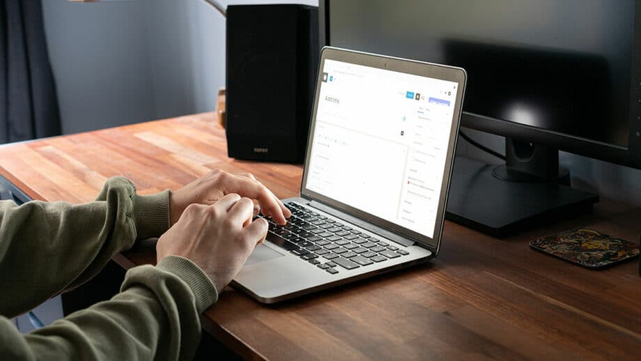 A man using a laptop on a desk and working on a project.