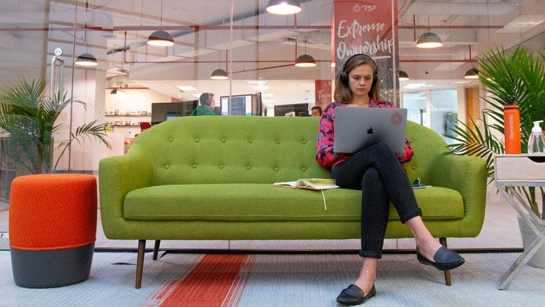 A woman sitting on a green couch.