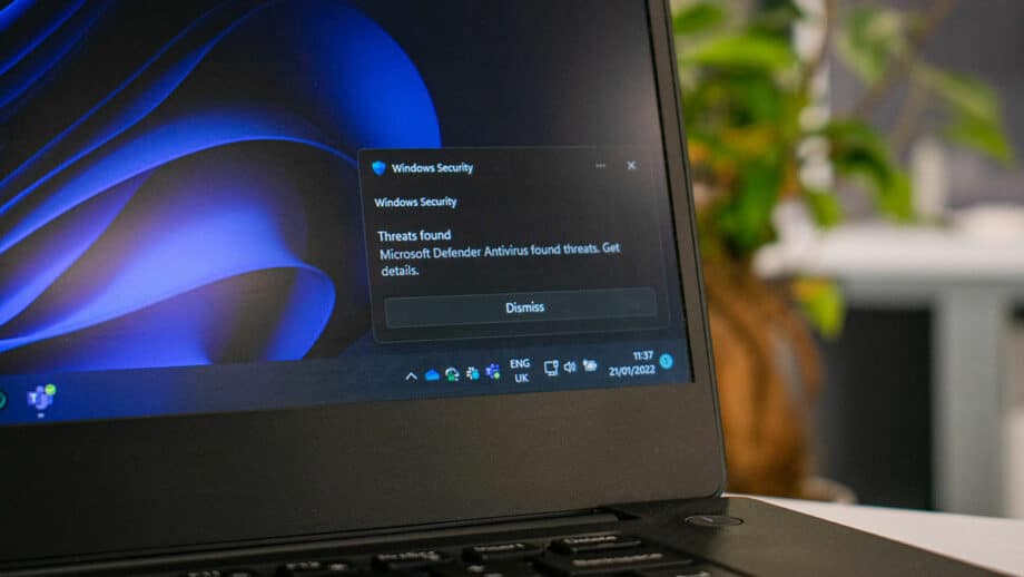 A windows laptop with a blue screen on it showing security alert.