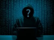 A hooded figure at a laptop with a question mark over their face, set against a backdrop of digital numbers.
