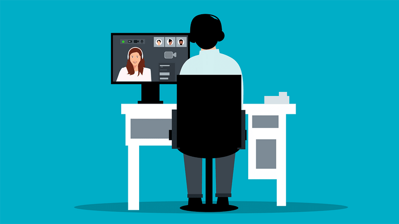 A man sitting at a desk with a person on a computer screen.