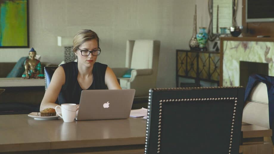 A woman sitting at a table working on her laptop.