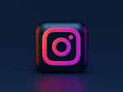 A 3D square icon with the Instagram logo in pink and orange gradient on a dark blue background.
