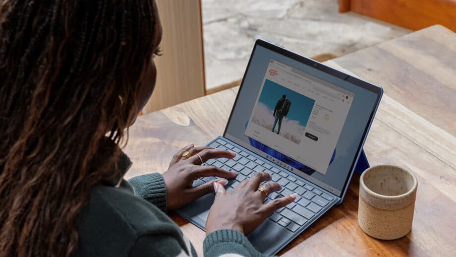 A woman using a laptop on a wooden table.