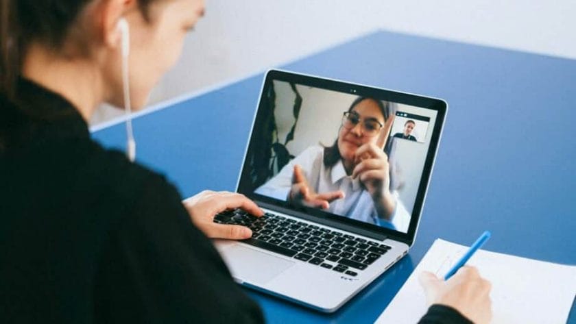 A woman is using a laptop to make a video call.
