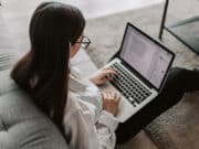 A woman working on her laptop in a living room.