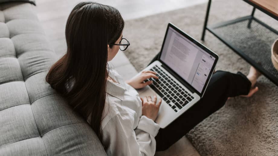 A woman working on her laptop in a living room.