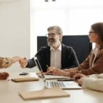 A group of business people shaking hands at a meeting.