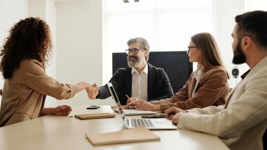 A group of business people shaking hands at a meeting.