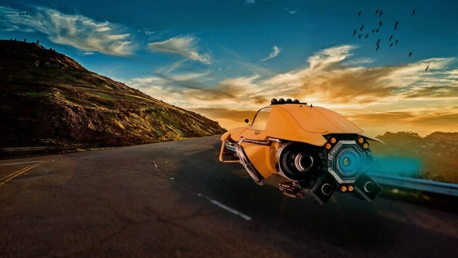 A futuristic yellow flying car hovers on an empty road at sunset, with a hill in the background and a flock of birds in the sky.