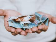 A man holding a pile of money in his hands.
