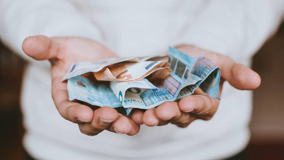 A man holding a pile of money in his hands.