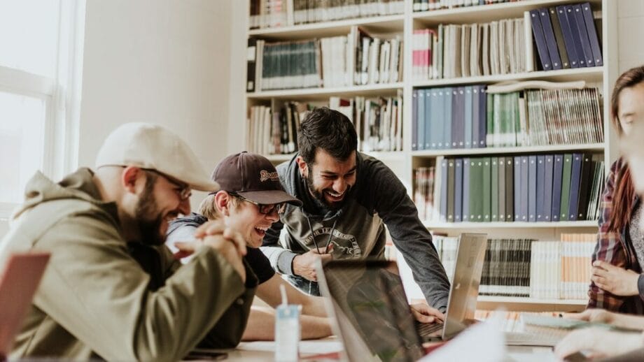 A group of people working on laptops in a library.