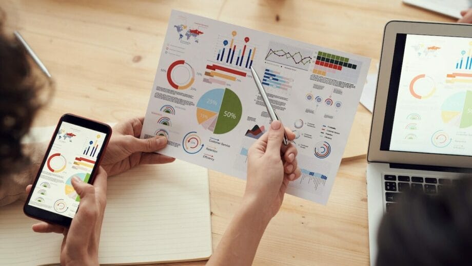 A group of people looking at graphs on a laptop as part of their marketing strategies.