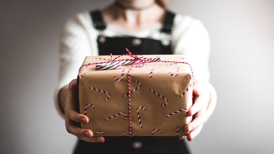 Cross-Border ECommerce Logistics: A woman holding a gift wrapped in brown paper.