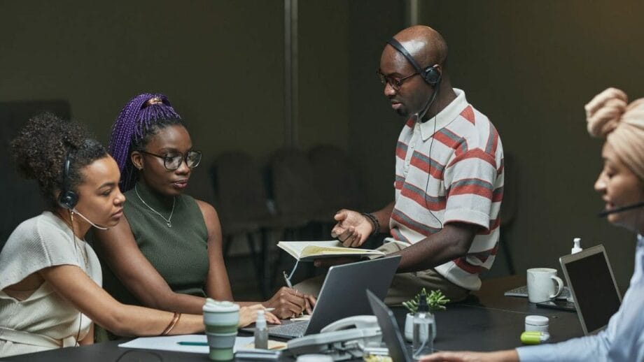 A group of people working together in a conference room of a call center.