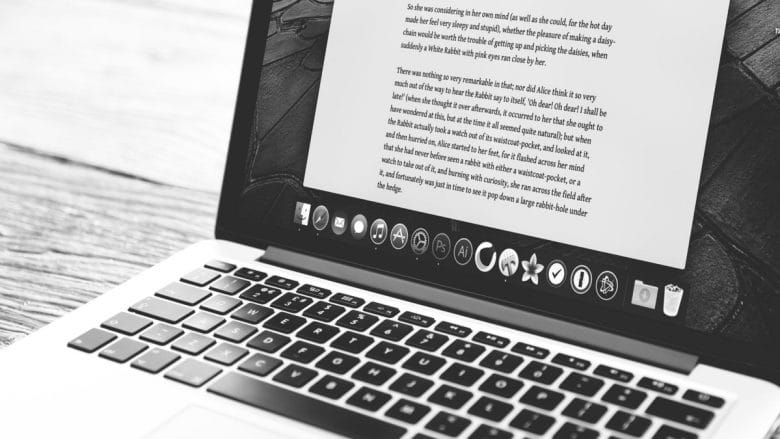 A macbook pro laptop with a writing screen on.