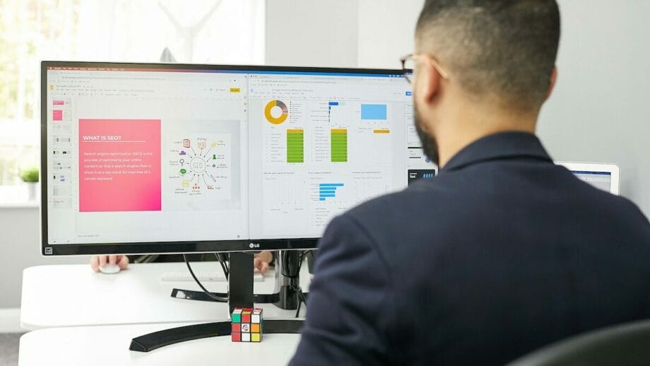 A man sitting at a desk looking at a computer screen.