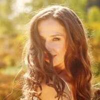 Emma Jones, the author of this article, with long brown hair posing in a field.