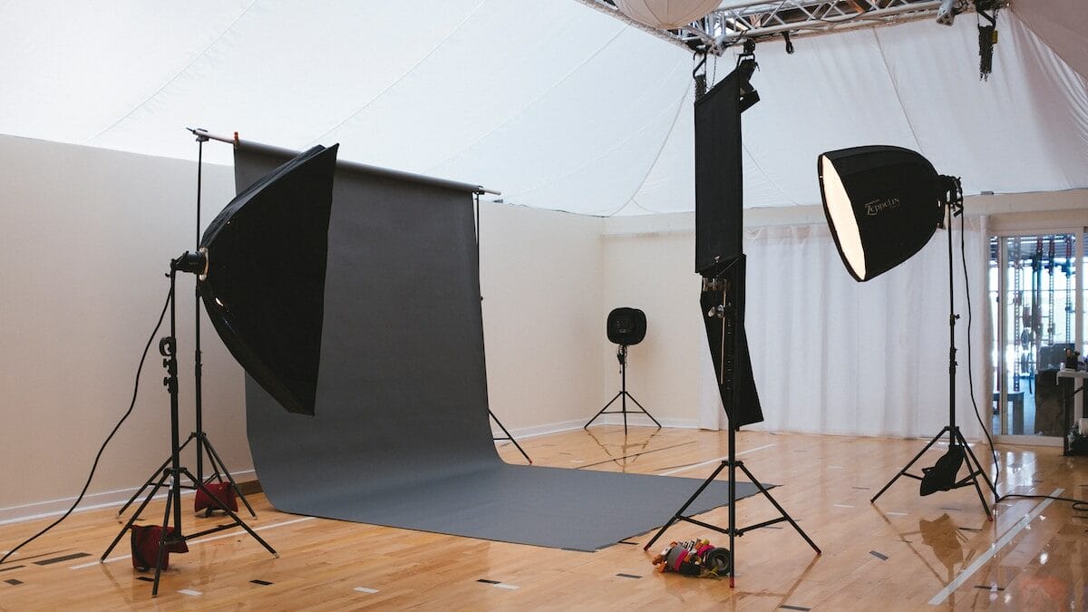 A photo studio with lighting equipment and a wooden floor.