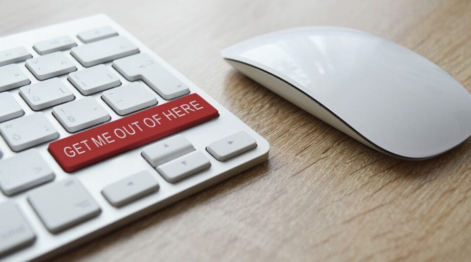 A computer keyboard with a red button that says get me out of here.