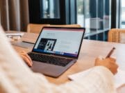 A woman working on a laptop at a table.