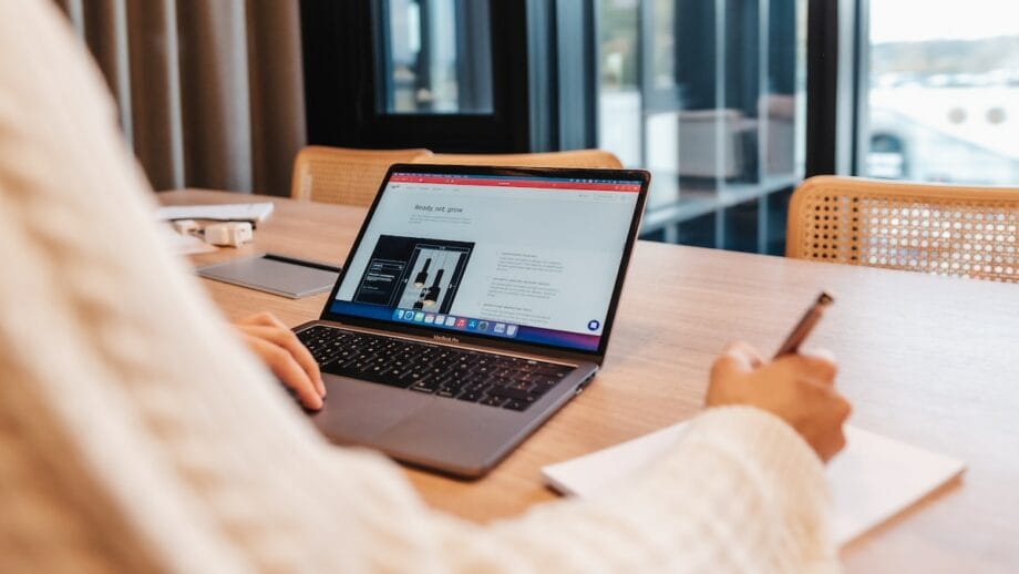 A woman working on a laptop at a table.