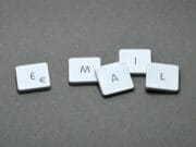 Five keyboard keys arranged to spell EMAIL on a gray surface.