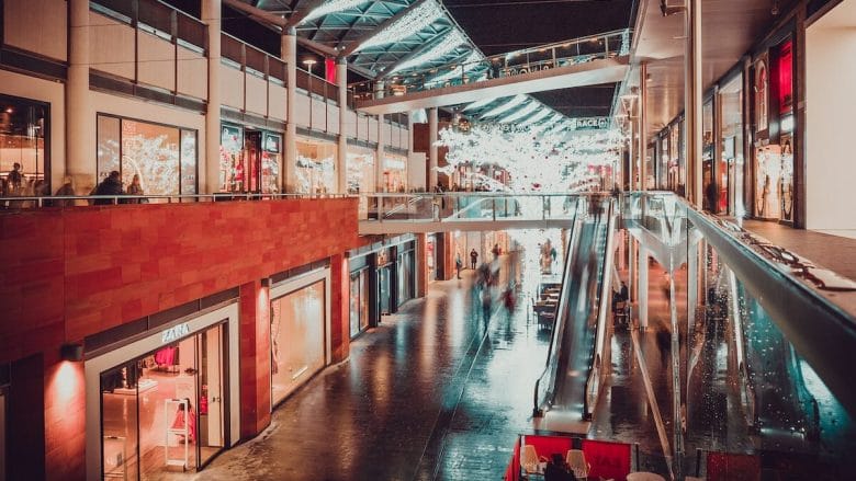A shopping mall at night with people walking around.
