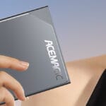 A woman is holding up an ACEMAGIC S1 Mini PC.
