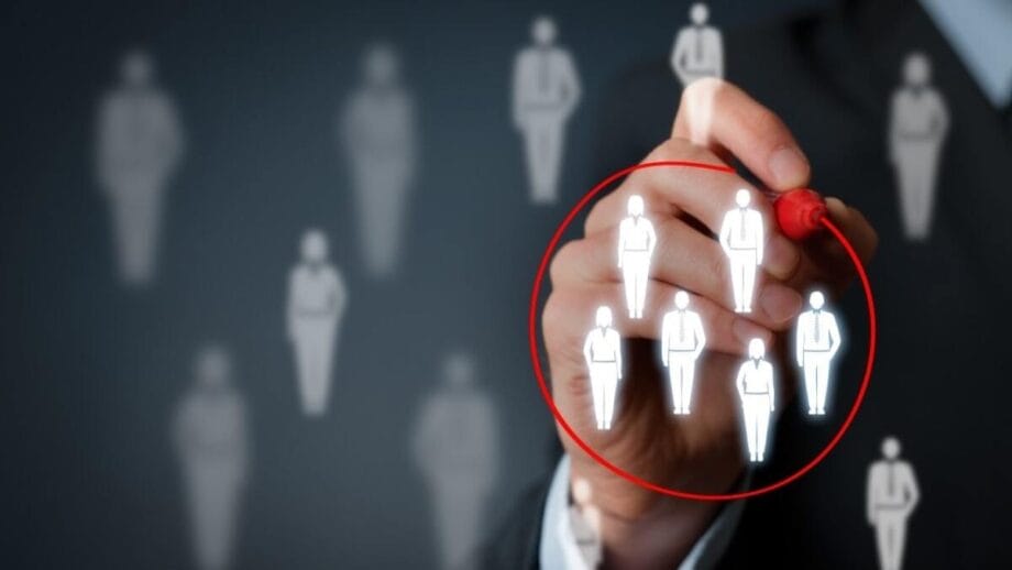 A hand draws a red circle around a group of illuminated human icons, representing targeted selection or audience segmentation.