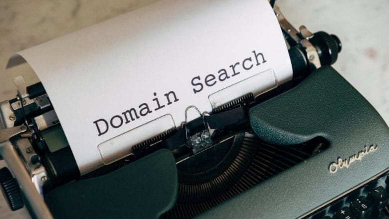 A green typewriter with a sheet of paper displaying the words "Domain Search.