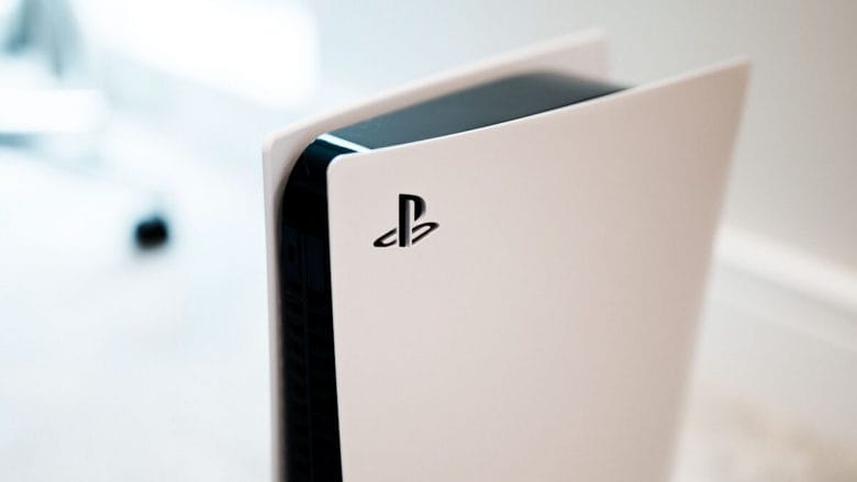 A close-up of a PlayStation 5 console with a white exterior and black interior, displaying the PlayStation logo on its side.