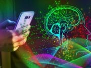 Person holding a smartphone, with a digital illustration of a brain and a head profile surrounded by colorful neural network lines, symbolizing the intersection of technology and artificial intelligence.