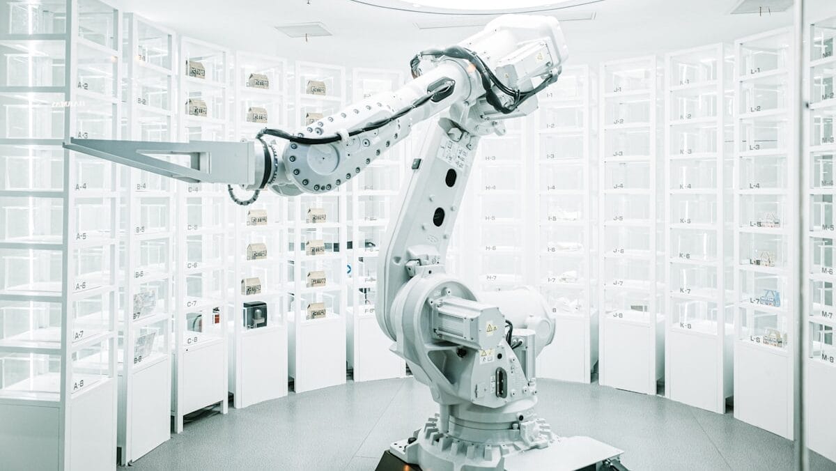 A sleek robotic arm in a well-lit, modern laboratory filled with organized rows of containers.