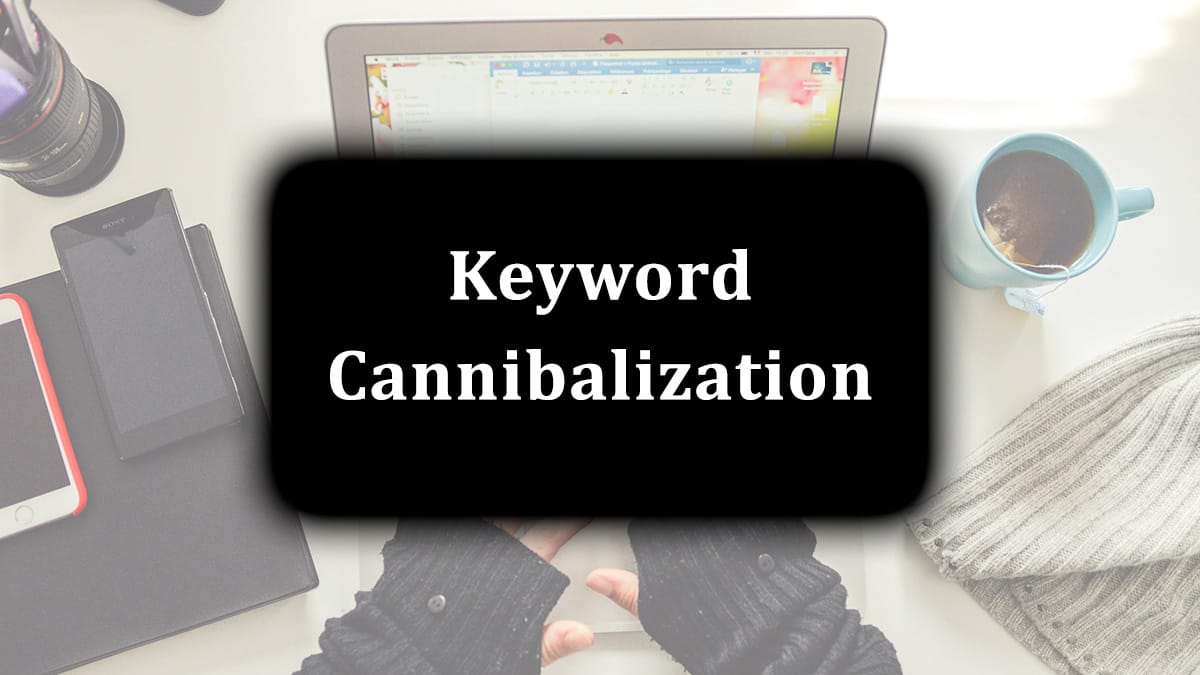 Laptop, smartphone, and coffee on a desk with "Keyword Cannibalization" text overlay.