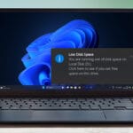 Laptop displaying a low disk space warning on Windows desktop.