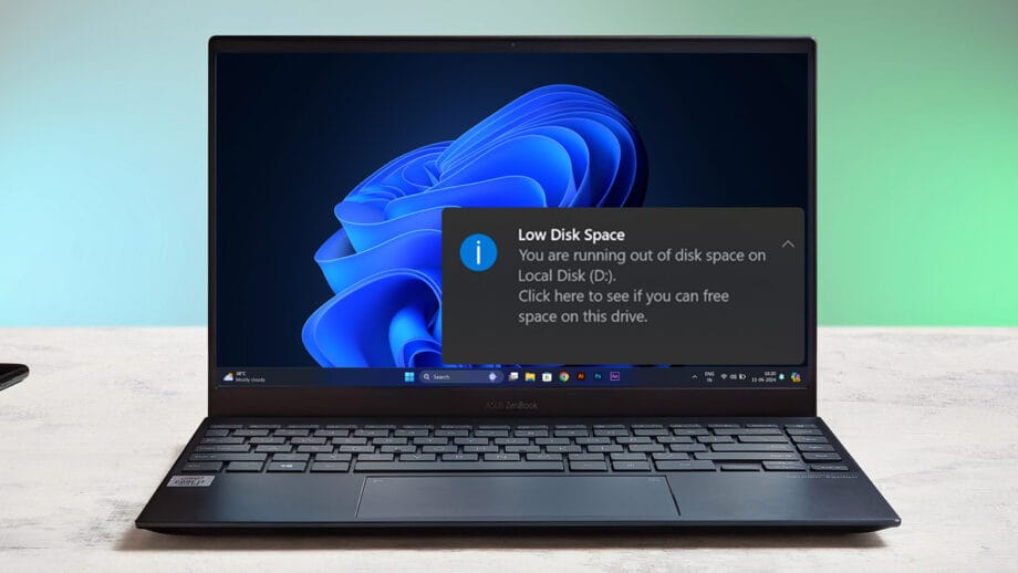 Laptop displaying a low disk space warning on Windows desktop.