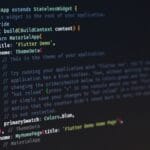 Close-up of computer screen displaying programming code for a Flutter app, featuring class definition, widget build method, and theme data settings.