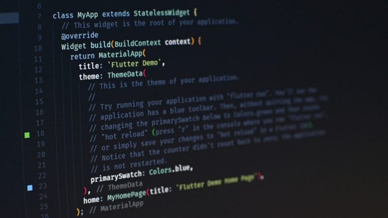 Close-up of computer screen displaying programming code for a Flutter app, featuring definition, widget build method, and theme data settings.