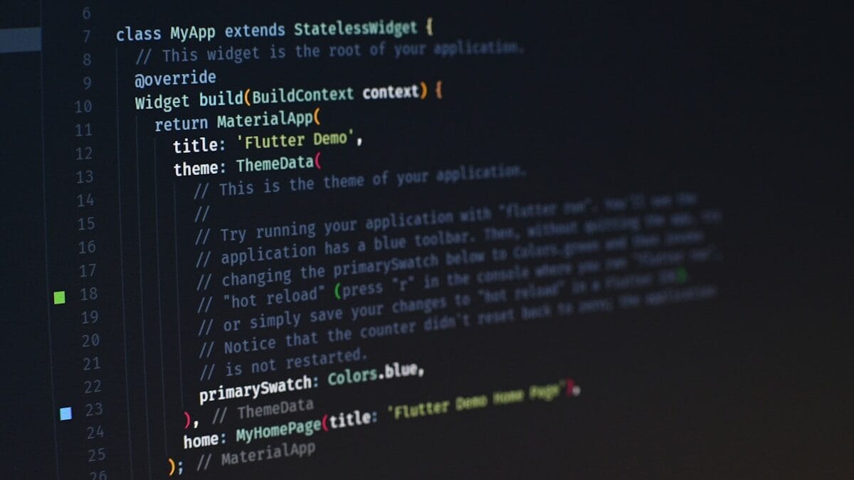 Close-up of computer screen displaying programming code for a Flutter app, featuring definition, widget build method, and theme data settings.