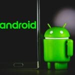 A smartphone displaying "android" next to a small green Android figure on a dark background.