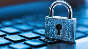 A silver padlock sits on a computer keyboard, symbolizing cybersecurity and data protection.