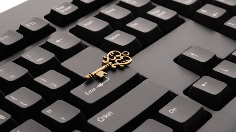 An ornate key lies atop a black computer keyboard, positioned across the Shift and Enter keys.