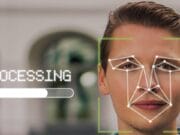 A man outdoors with facial recognition graphics and a processing bar overlayed on his face.