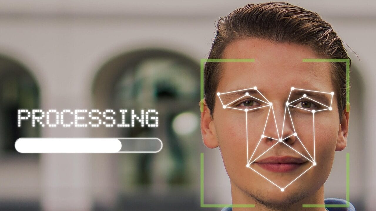 A man outdoors with facial recognition graphics and a processing bar overlayed on his face.