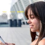 Woman outdoors looking at her phone, with a row of five emoticon rating icons and star ratings superimposed in front of her.
