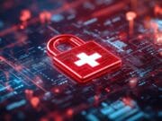 A digital padlock with a white medical cross symbol sits on a circuit board, representing cybersecurity in healthcare technology.