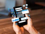 Person holding a smartphone with various digital financial and data analysis graphics displayed as floating overlays.